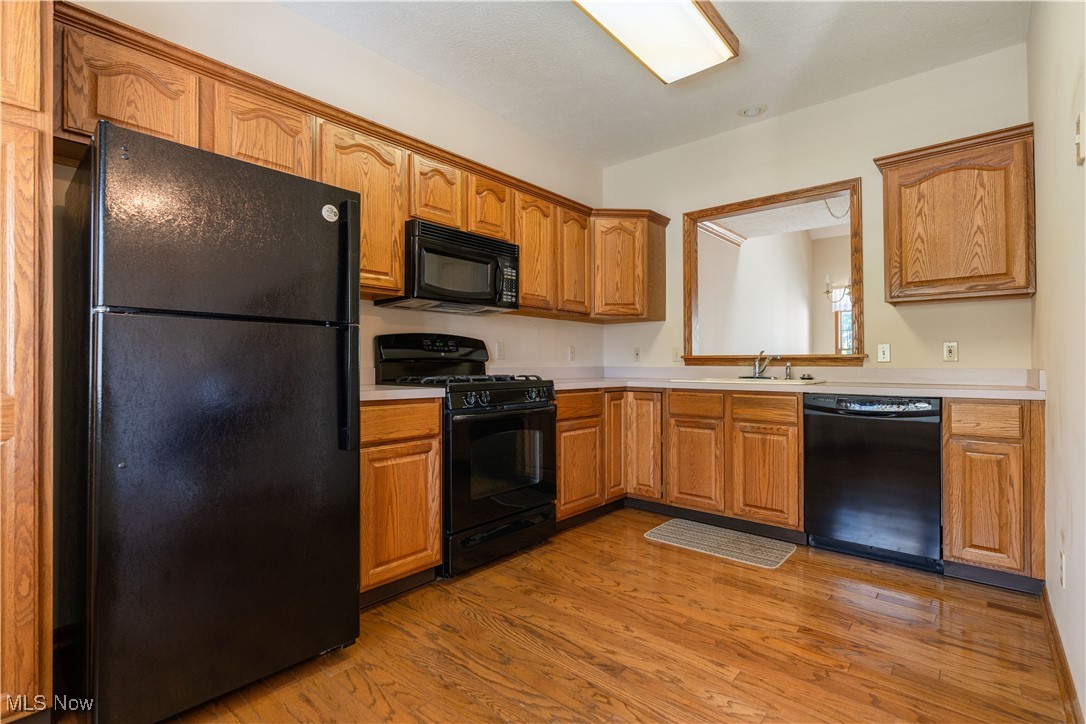 2603 Charing Cross Road Northwest Canton, OH 44708 - Photo 9 of 24 Kitchen featuring black appliances, sink, and light hardwood / wood-style flooring