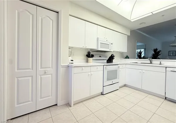 a kitchen with white cabinets sink and white appliances