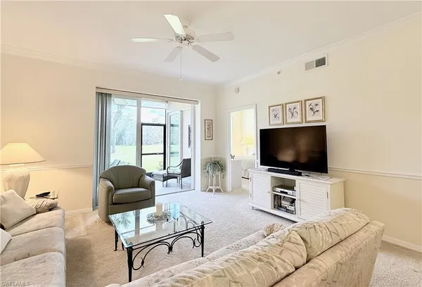 a bedroom with a bed lamp and a large window with the outer view