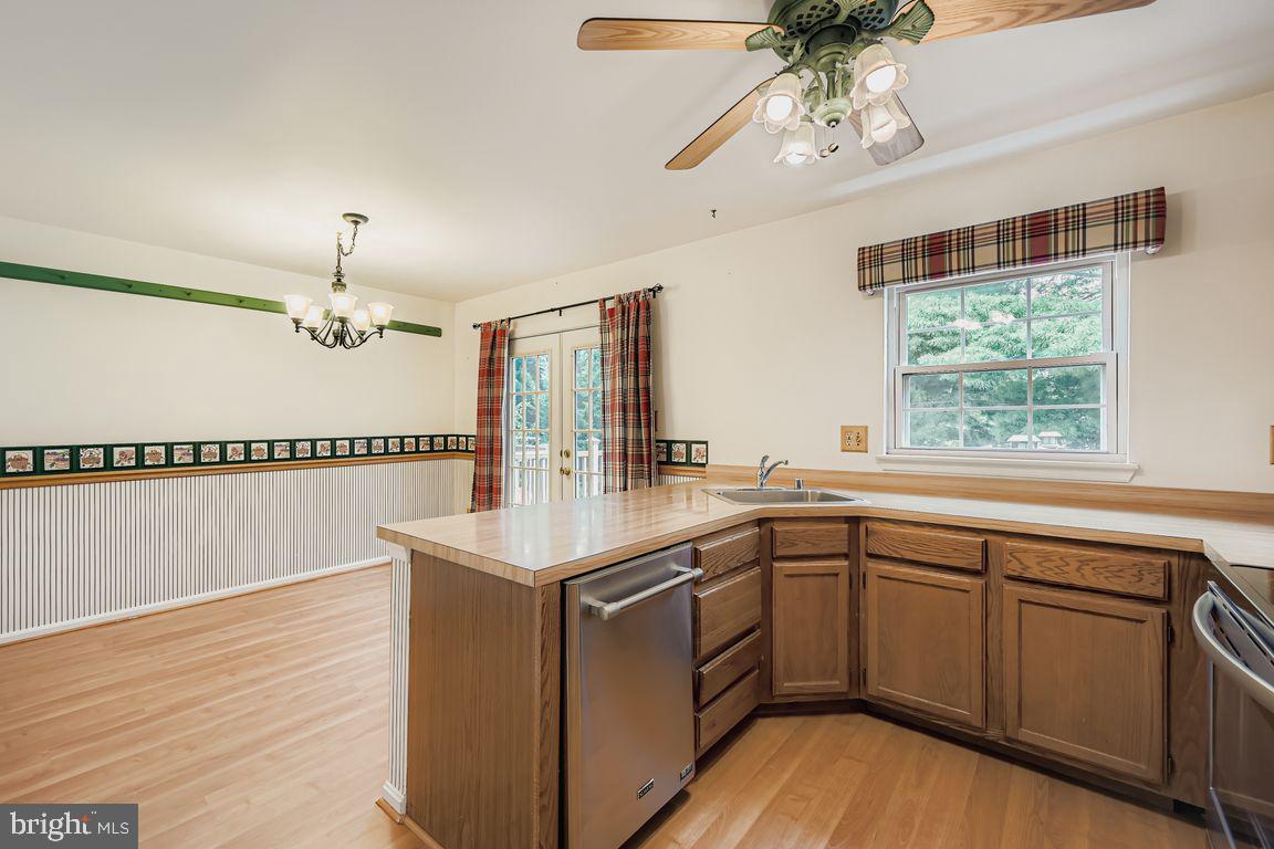 9 Bridgeview Court Baltimore, MD 21236 - Photo 9 of 27 a kitchen with a sink dishwasher a stove and white cabinets with wooden floor