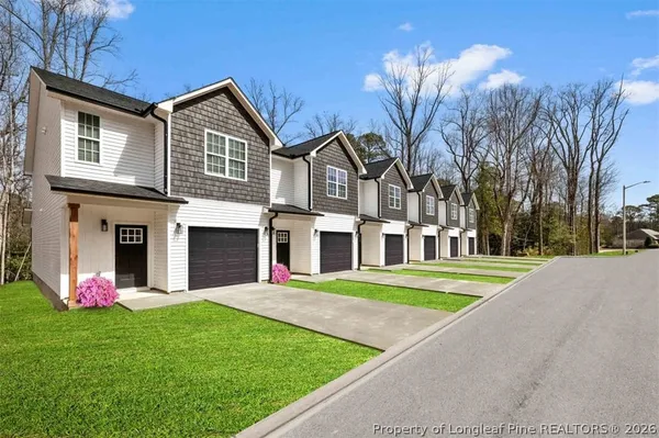 a front view of multiple houses with yard