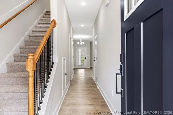 a view of a hallway with wooden floor and stairs