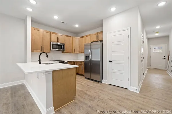 a kitchen with stainless steel appliances granite countertop a refrigerator and a sink