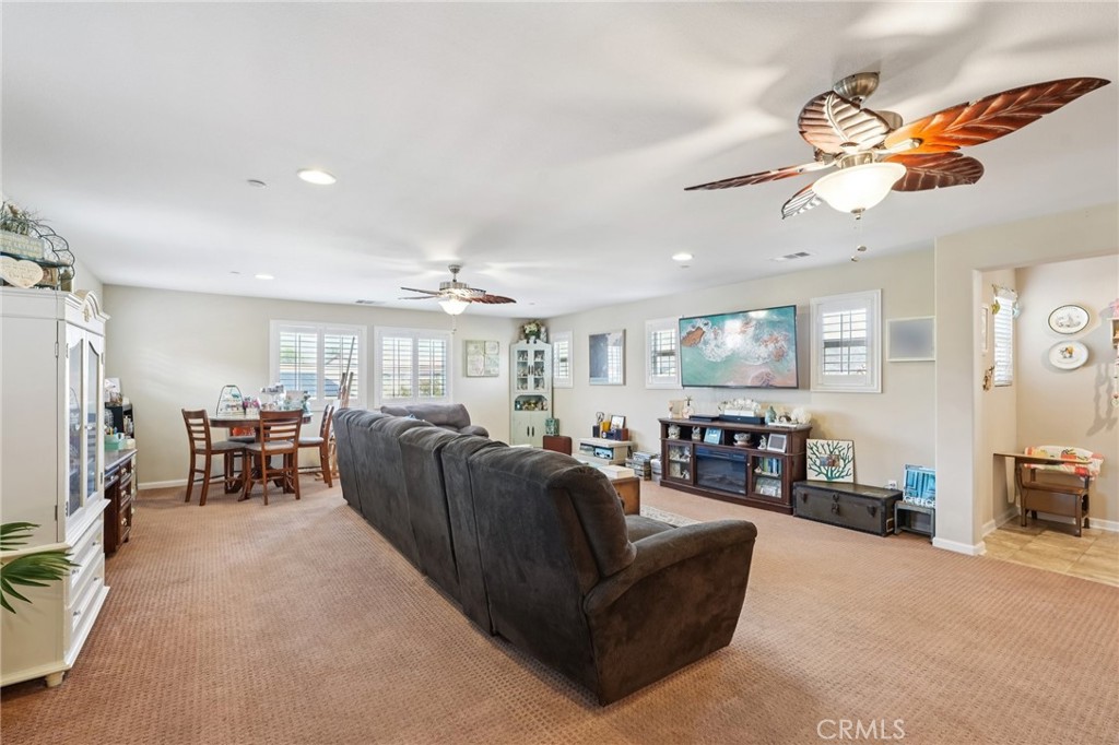 36274 Waxen Road Lake Elsinore, CA 92532 - Photo 15 of 65 a living room with furniture a chandelier a fireplace and a flat screen tv