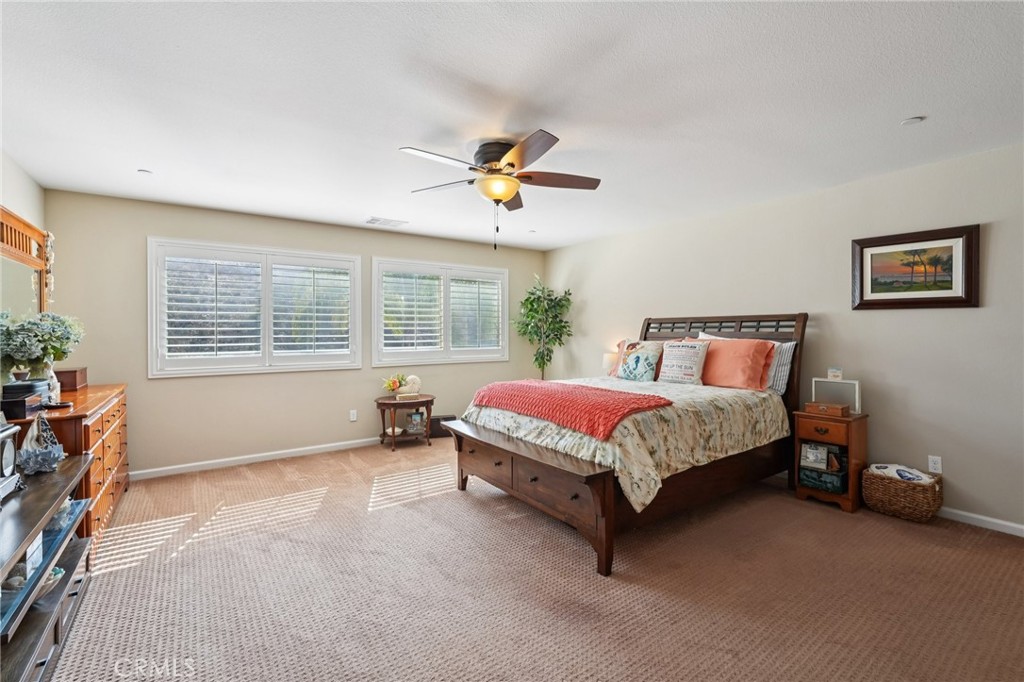 36274 Waxen Road Lake Elsinore, CA 92532 - Photo 17 of 65 a spacious bedroom with a bed and a chandelier
