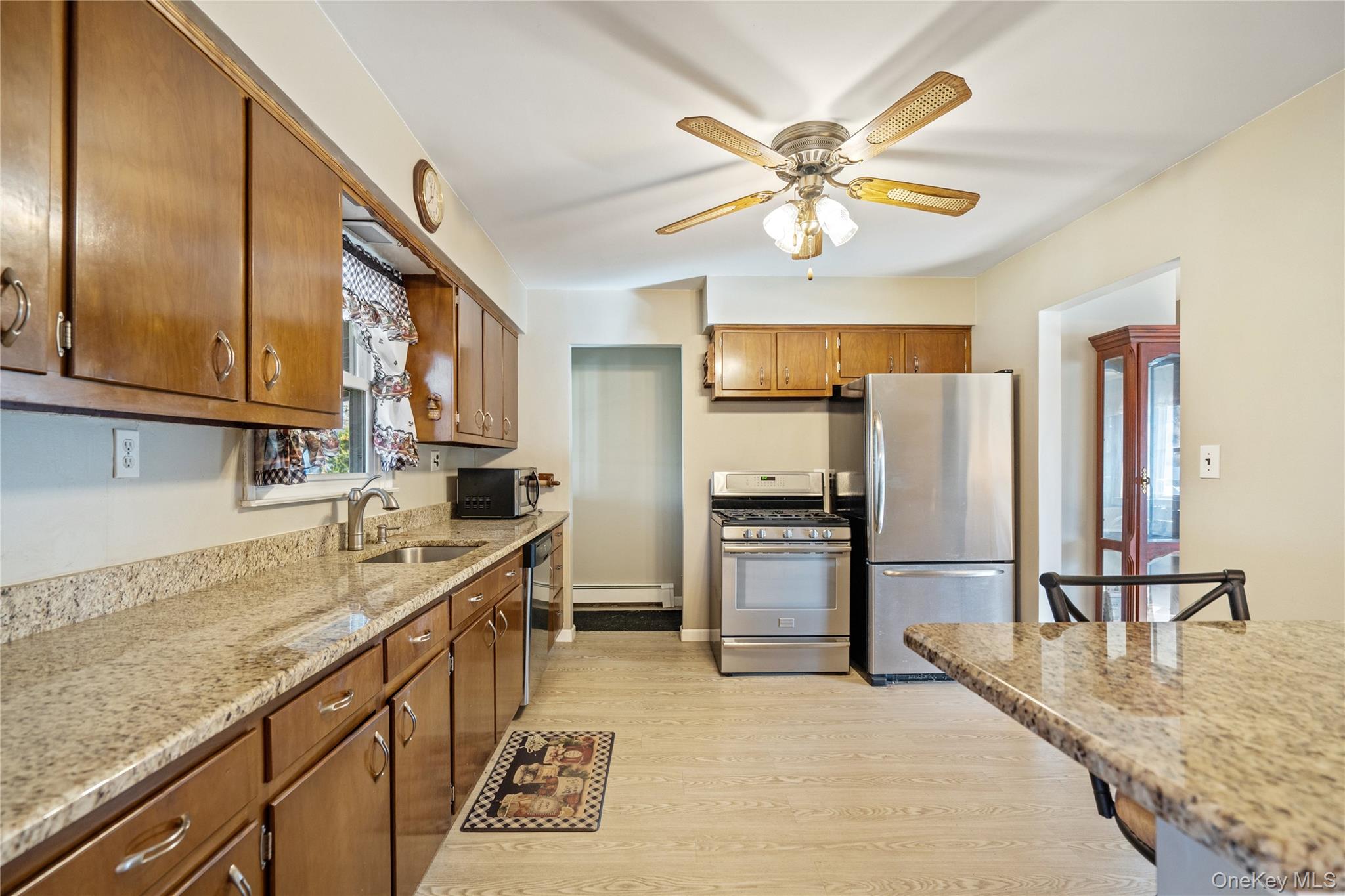 211 Mooney Pond Road Selden, NY 11784 - Photo 12 of 41 a kitchen with stainless steel appliances granite countertop a sink refrigerator and cabinets