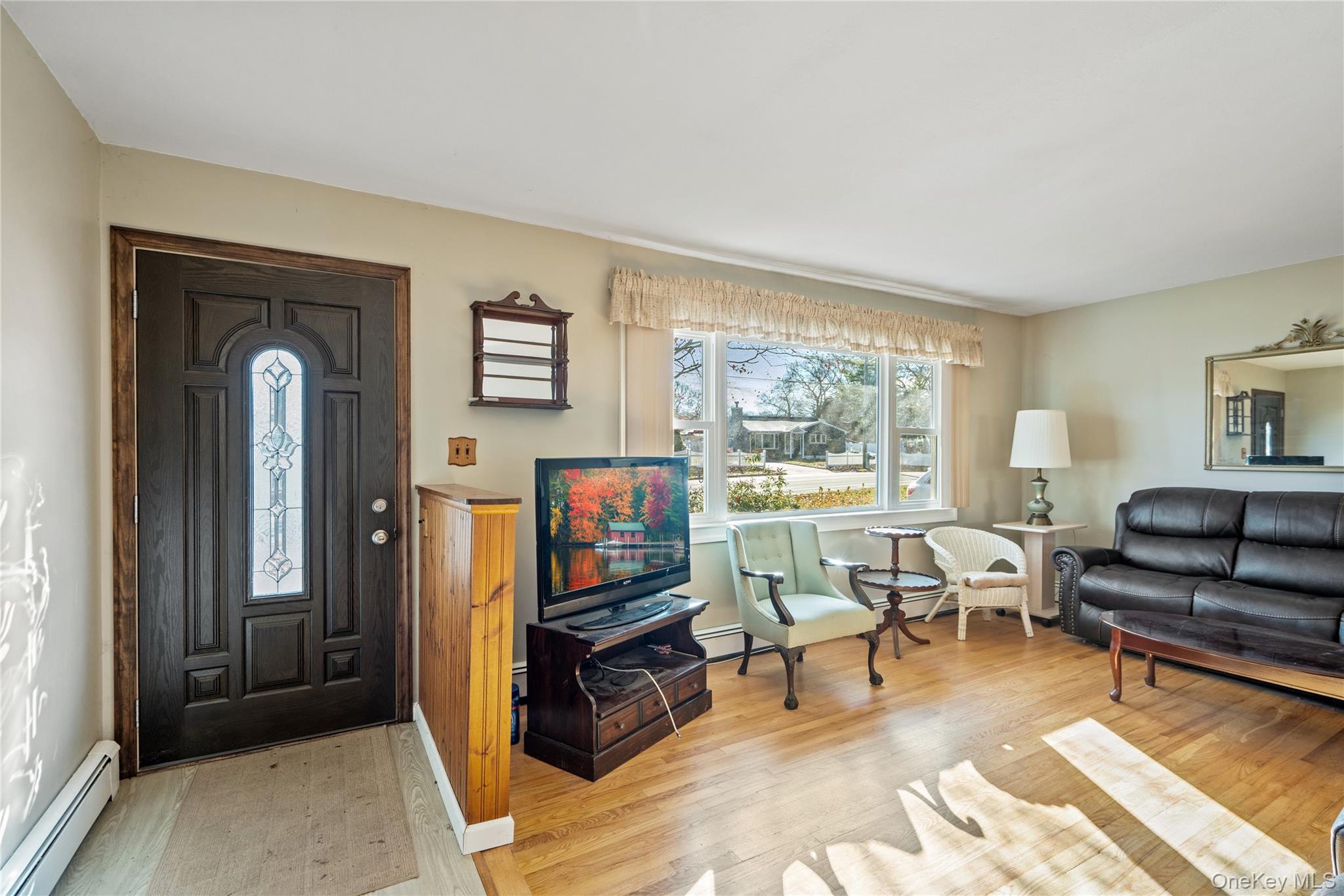 211 Mooney Pond Road Selden, NY 11784 - Photo 6 of 41 a living room with furniture and a flat screen tv