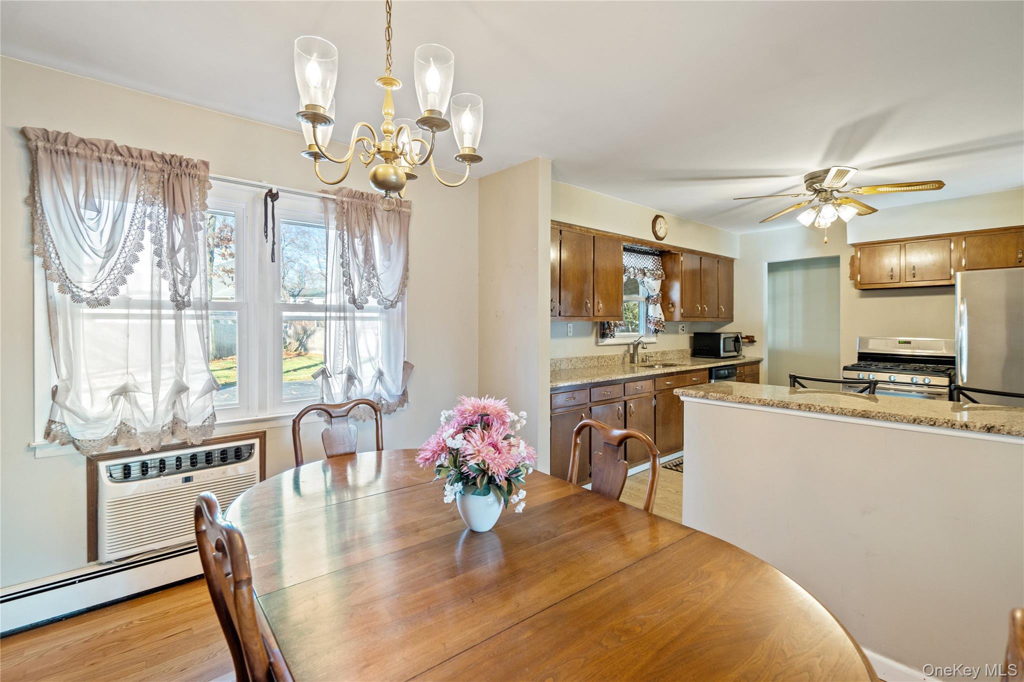 211 Mooney Pond Road Selden, NY 11784 - Photo 10 of 41 a kitchen with kitchen island granite countertop a dining table chairs stainless steel appliances and cabinets