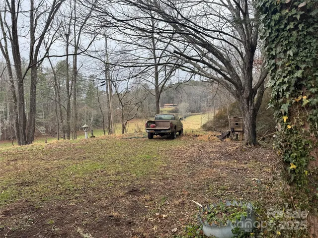 a car parked in front of a house with large trees