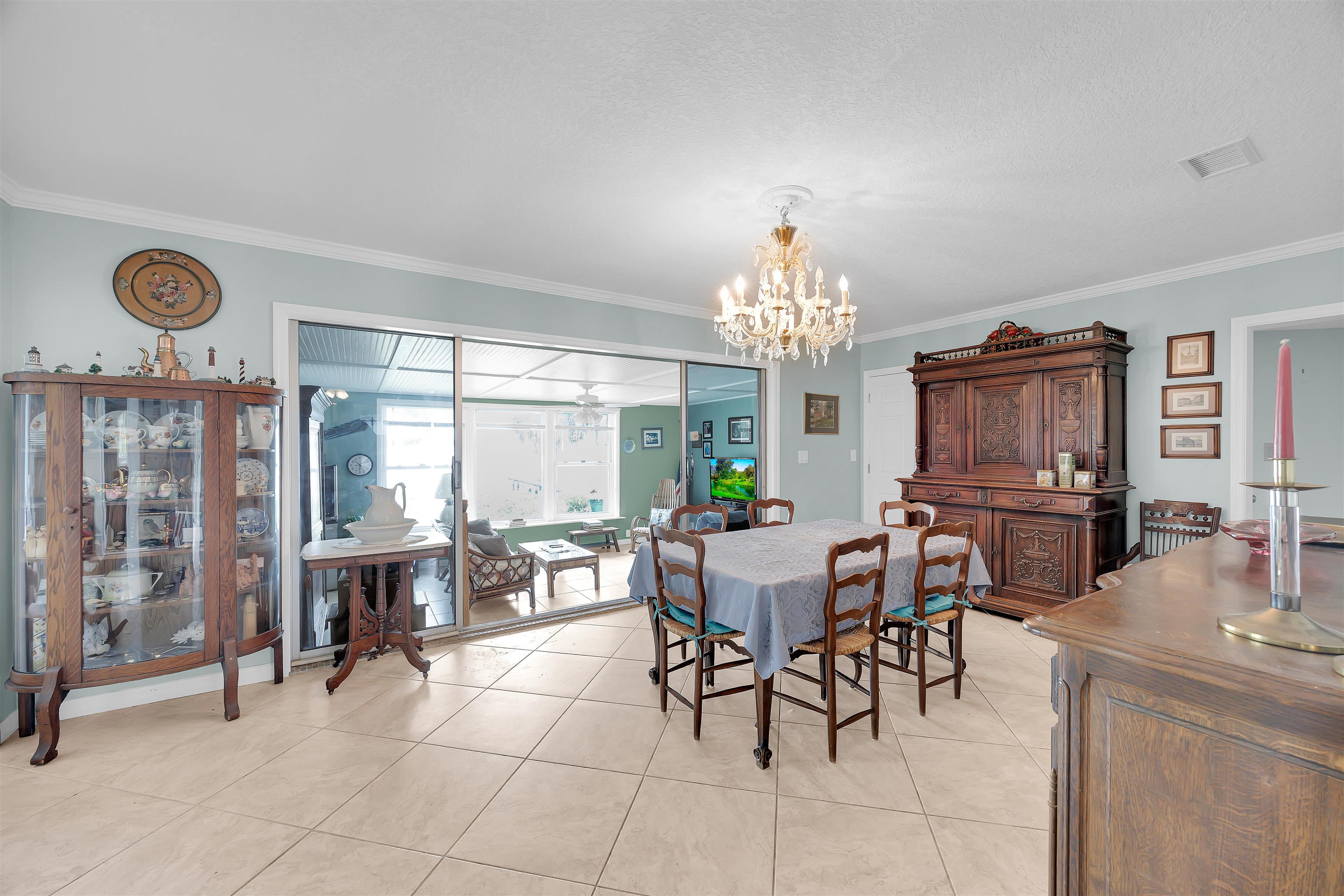 115 Sunset Point Road East Palatka, FL 32131 - Photo 28 of 67 Dining area with ornamental molding, light tile patterned floors, a chandelier, and ceiling fan