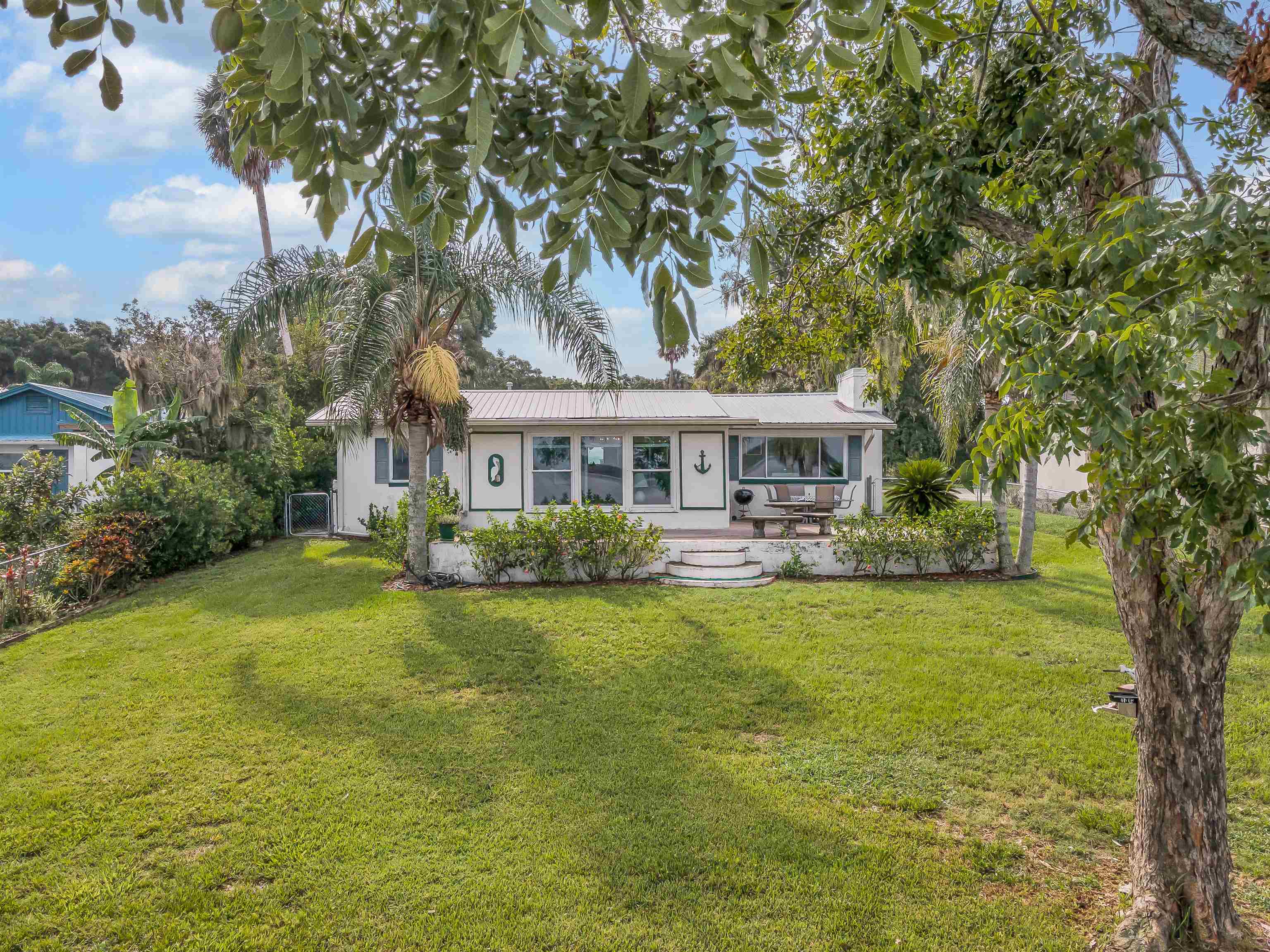 115 Sunset Point Road East Palatka, FL 32131 - Photo 35 of 67 Ranch-style house with a front lawn, a chimney, stucco siding, and a metal roof