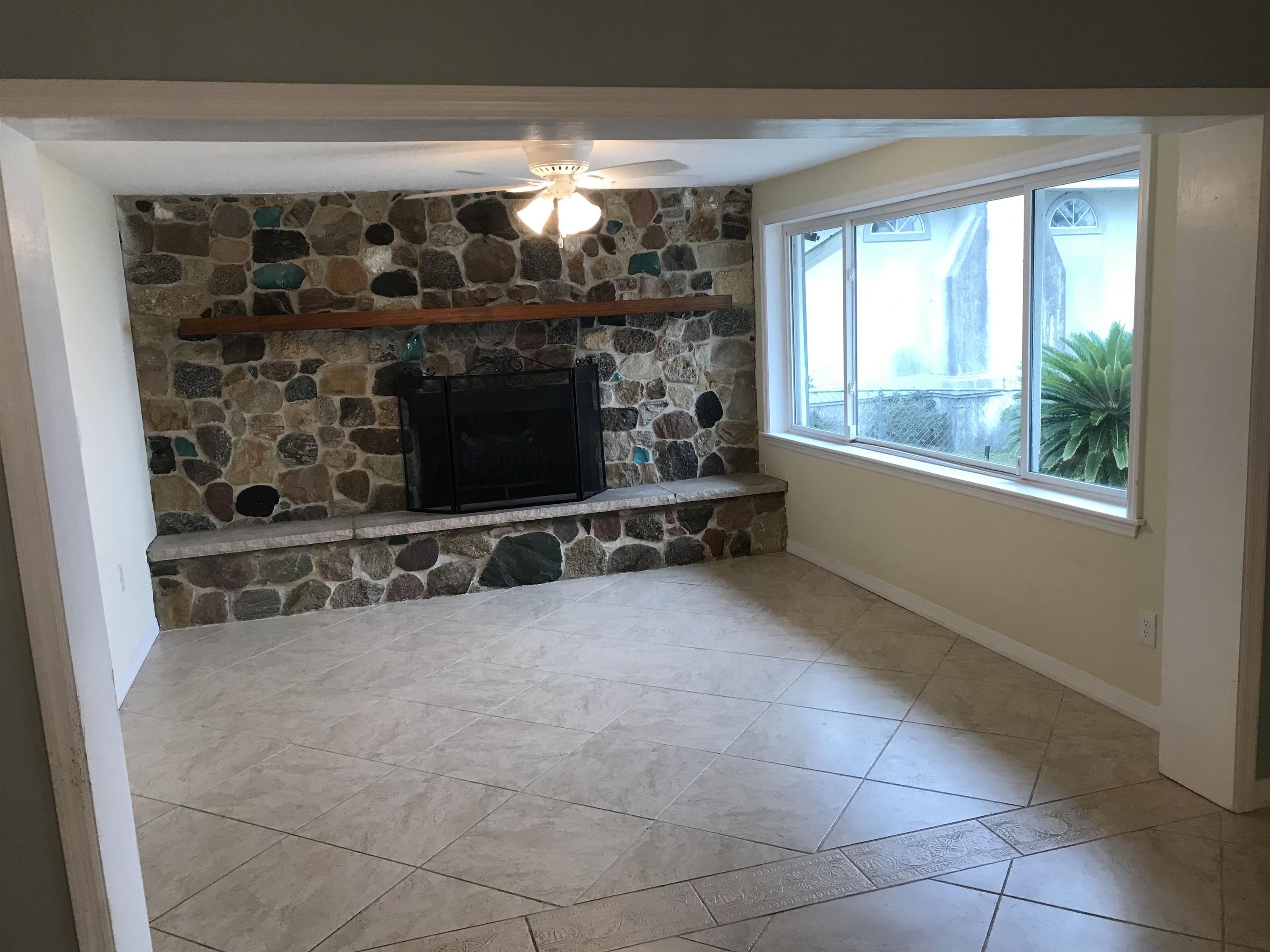 115 Sunset Point Road East Palatka, FL 32131 - Photo 43 of 67 Living area featuring a ceiling fan, a fireplace, and tile patterned floors