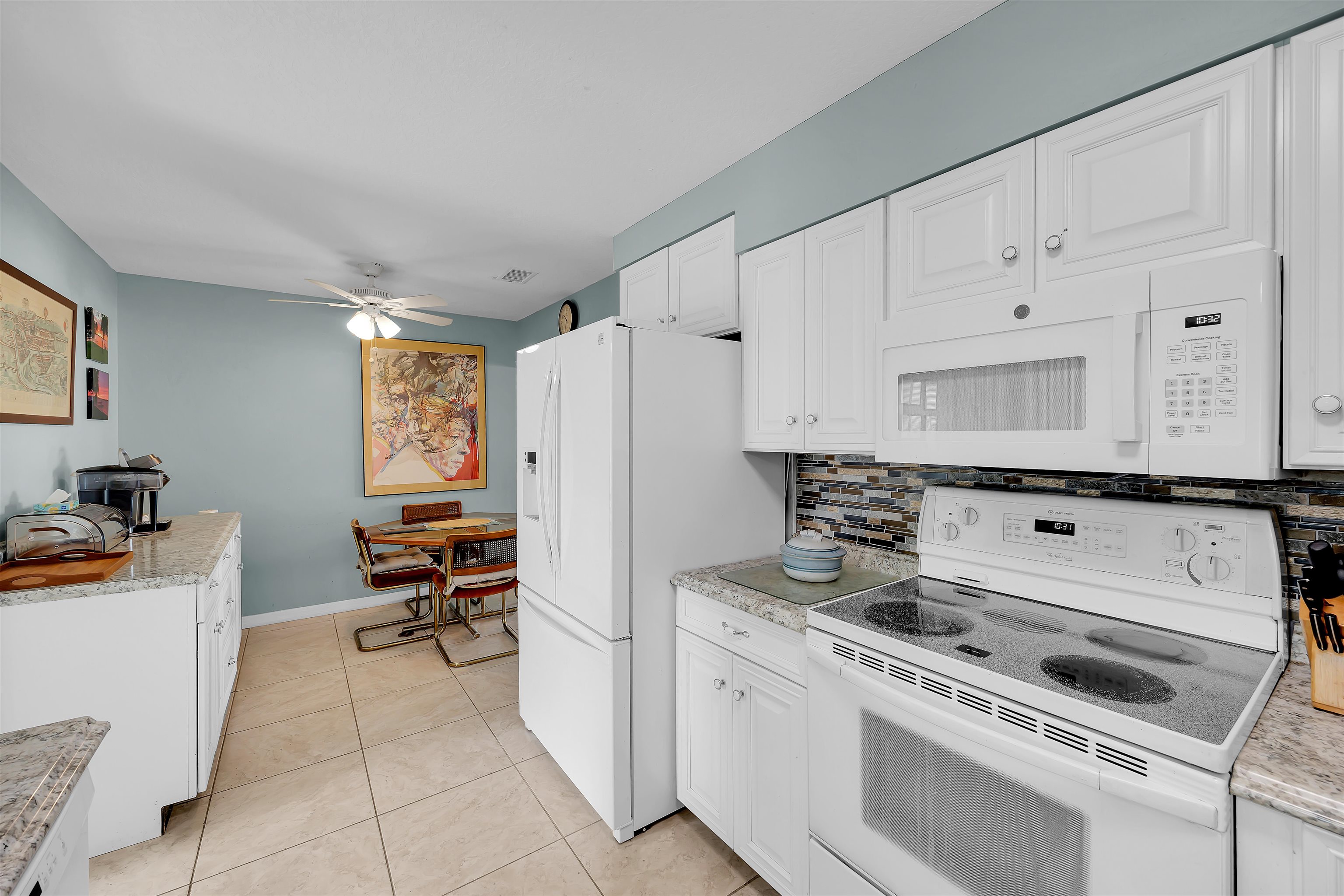 115 Sunset Point Road East Palatka, FL 32131 - Photo 49 of 67 Kitchen featuring white appliances, white cabinetry, backsplash, light tile patterned flooring, and a ceiling fan