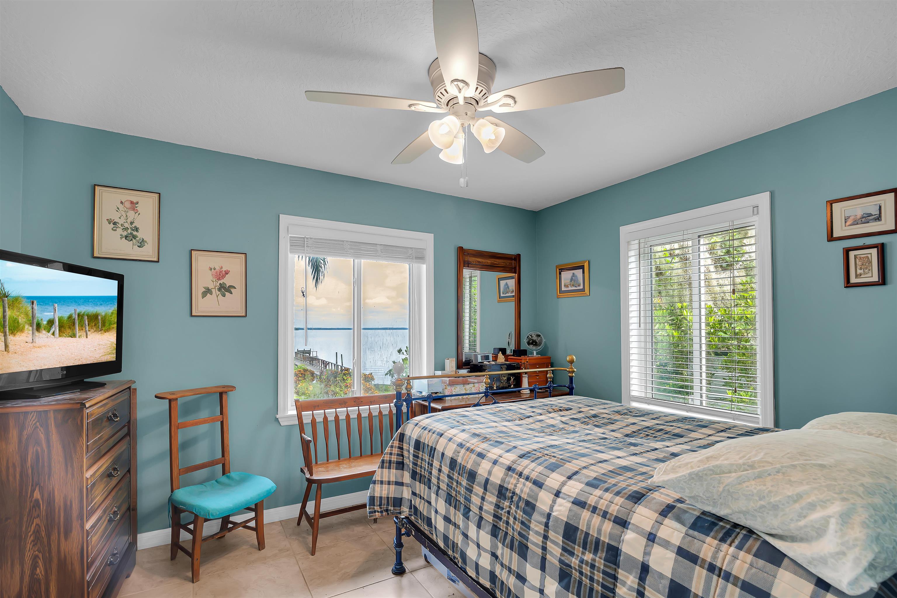 115 Sunset Point Road East Palatka, FL 32131 - Photo 58 of 67 Bedroom featuring multiple windows, light tile patterned flooring, and a ceiling fan