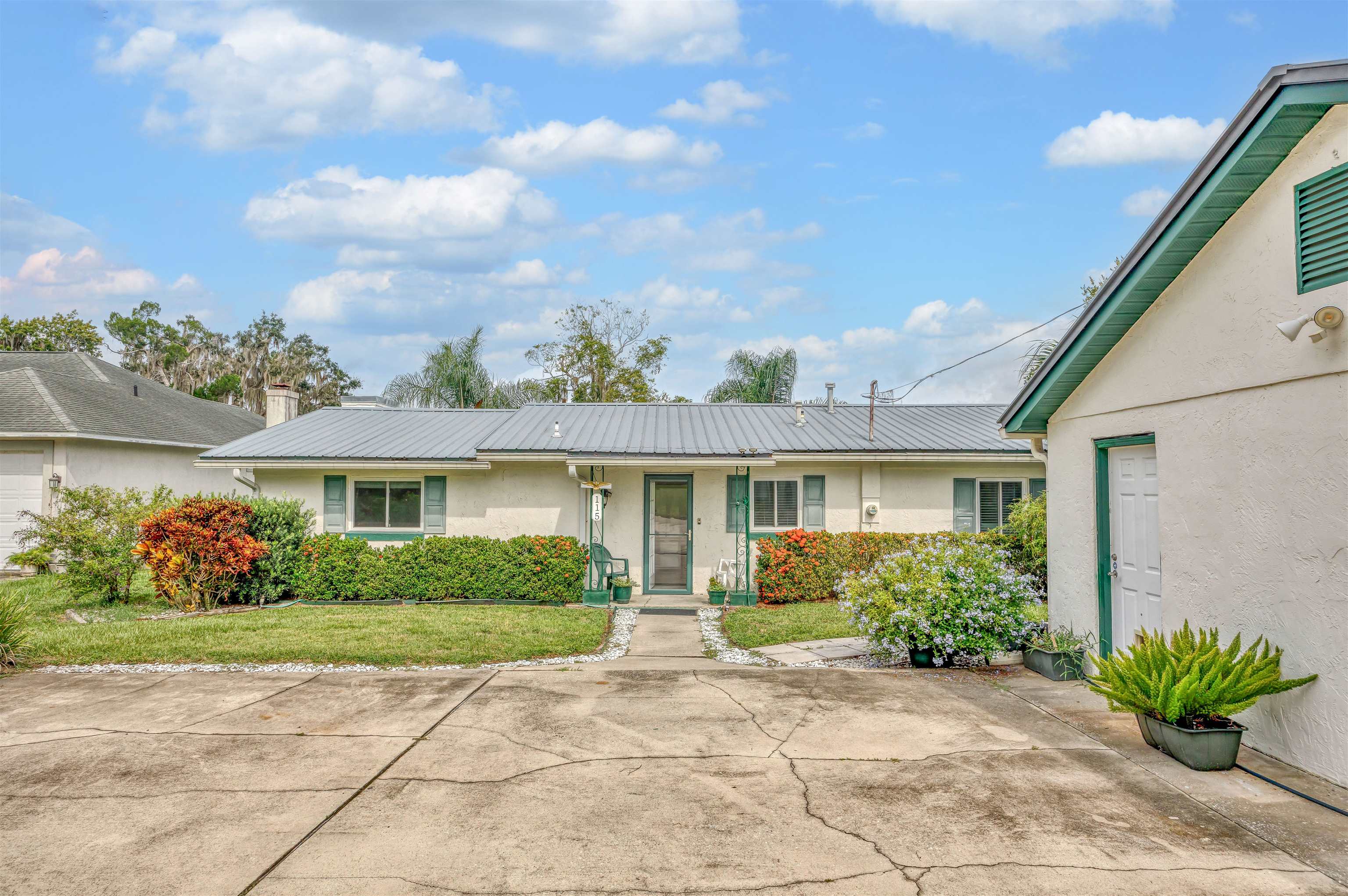 115 Sunset Point Road East Palatka, FL 32131 - Photo 64 of 67 Ranch-style home featuring stucco siding, a metal roof, a front lawn, and a chimney