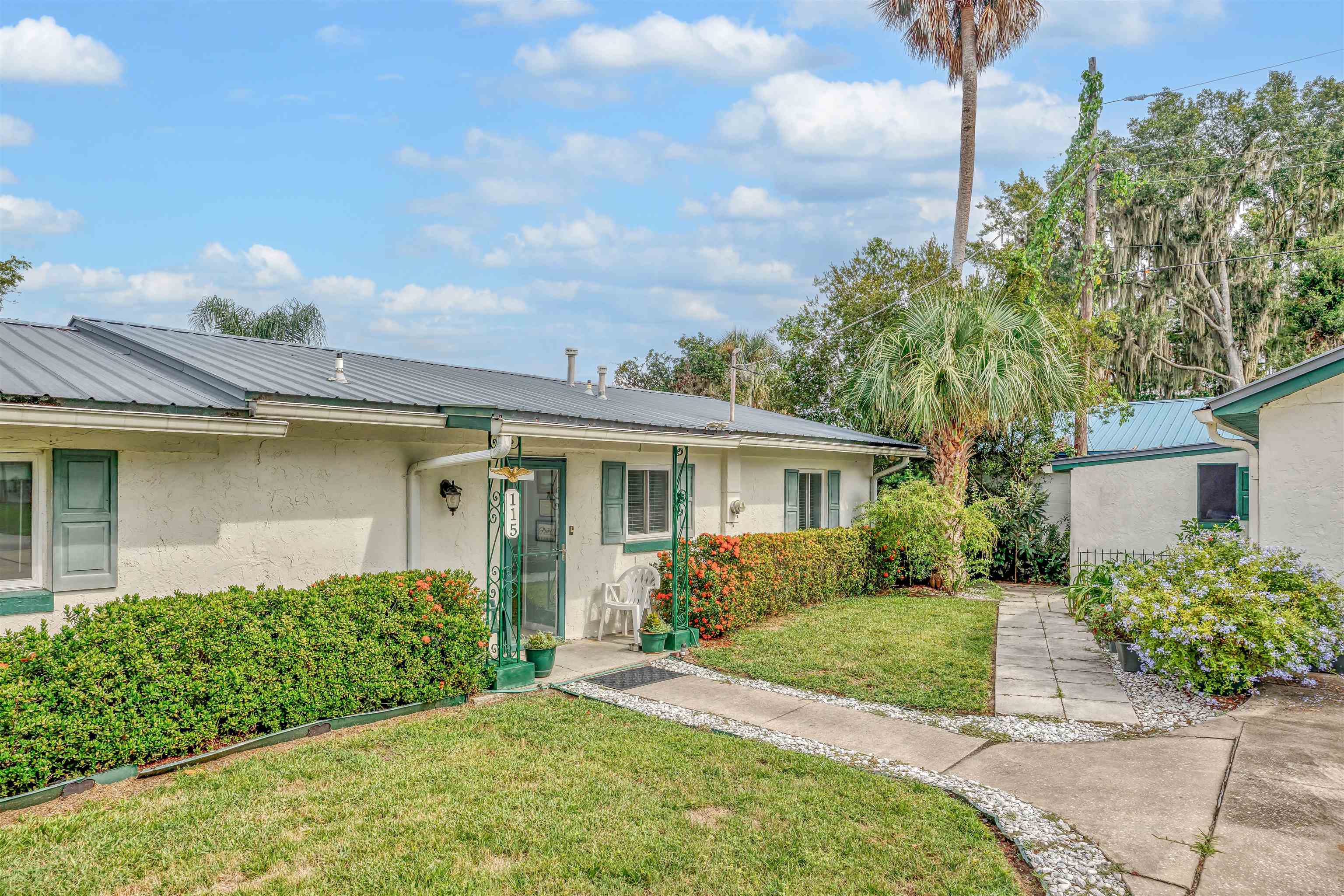 115 Sunset Point Road East Palatka, FL 32131 - Photo 65 of 67 View of front of house with a front yard, stucco siding, and a metal roof