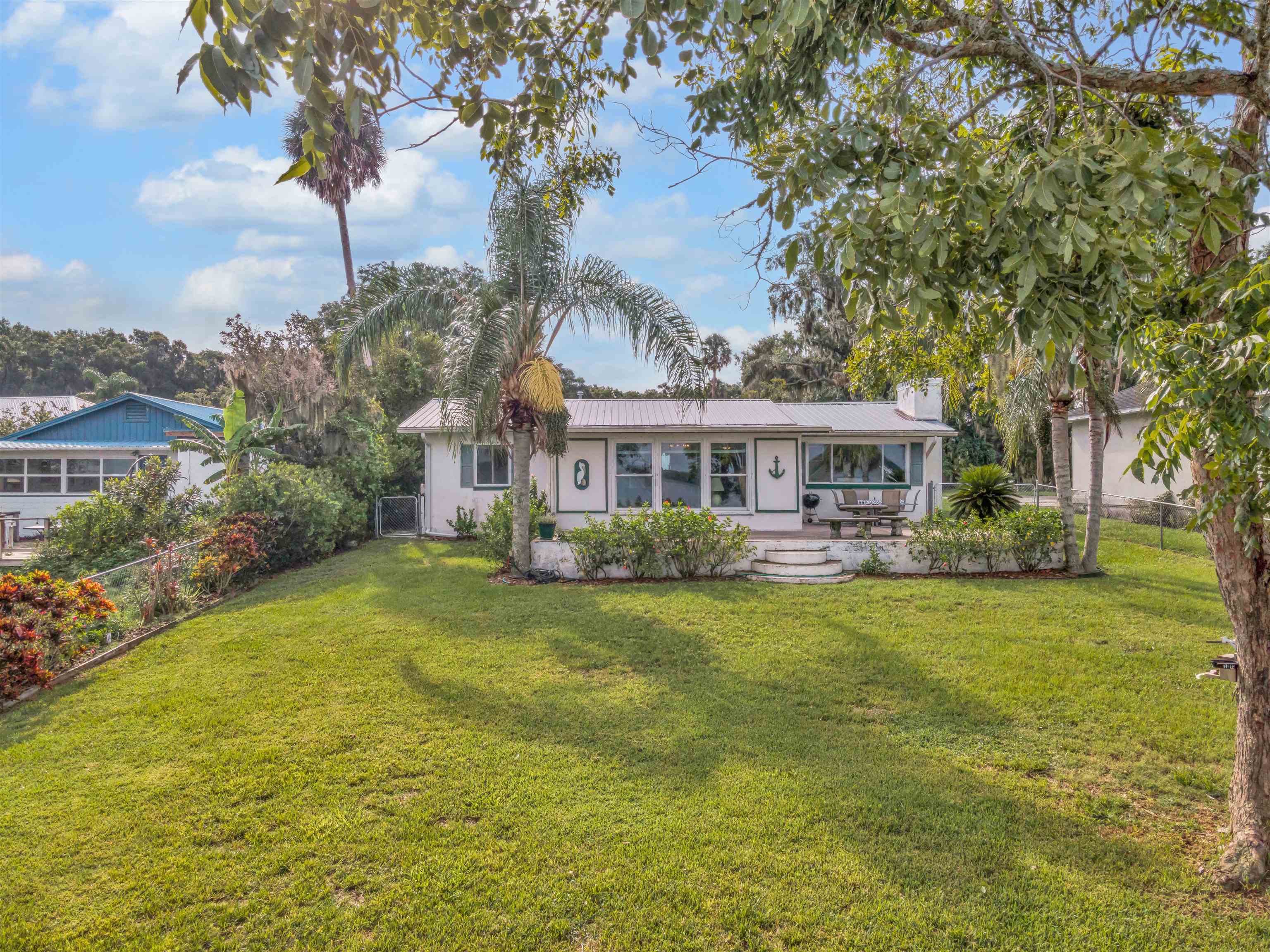 115 Sunset Point Road East Palatka, FL 32131 - Photo 10 of 67 View of front of home riverside with a metal roof, a chimney,Florida room sliders out.