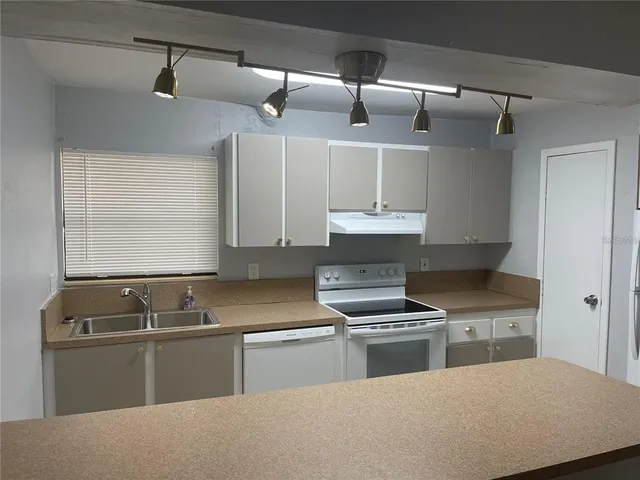 a kitchen with granite countertop a sink and a stove