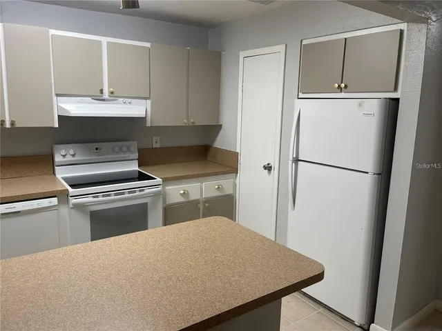 a kitchen with a refrigerator sink and cabinets