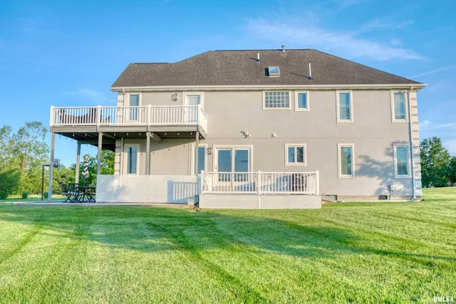 a front view of a house with a yard and trees