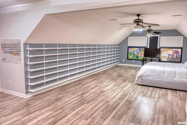 a view of a livingroom with a fireplace a ceiling fan and wooden floor