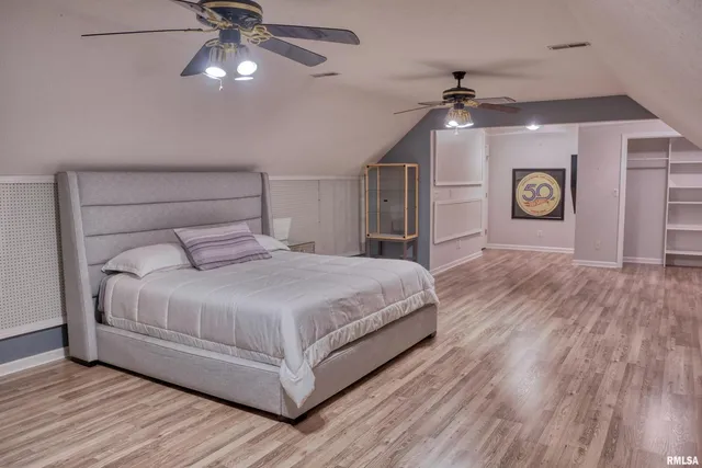 a bedroom with a large bed and a chandelier