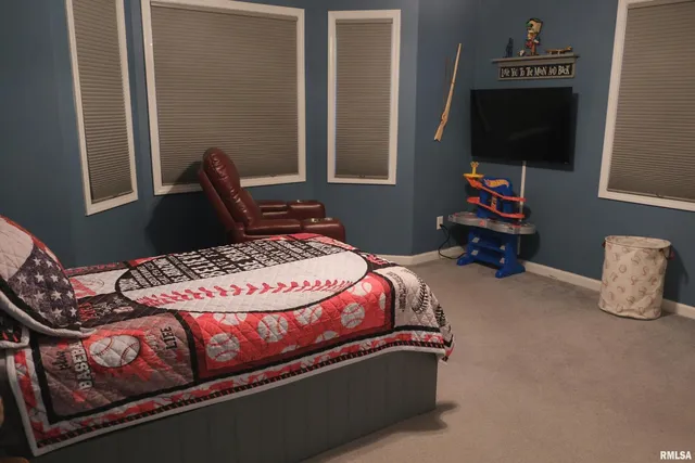 a bedroom with a bed and a flat tv screen on a dresser