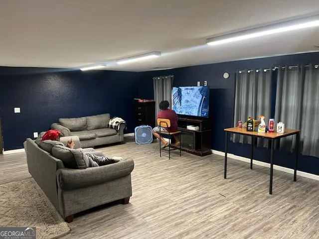 a living room with furniture and a wooden floor