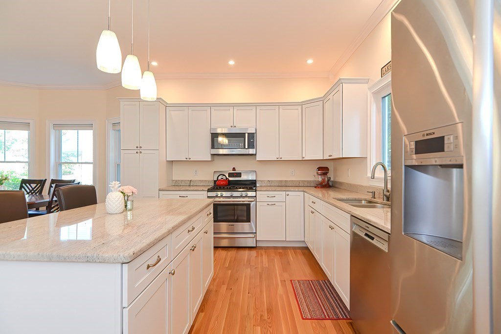 228 Cherry Street Newton, MA 02465 - Photo 2 of 42 a kitchen with stainless steel appliances granite countertop a refrigerator a sink dishwasher a stove and white countertops with wooden floor