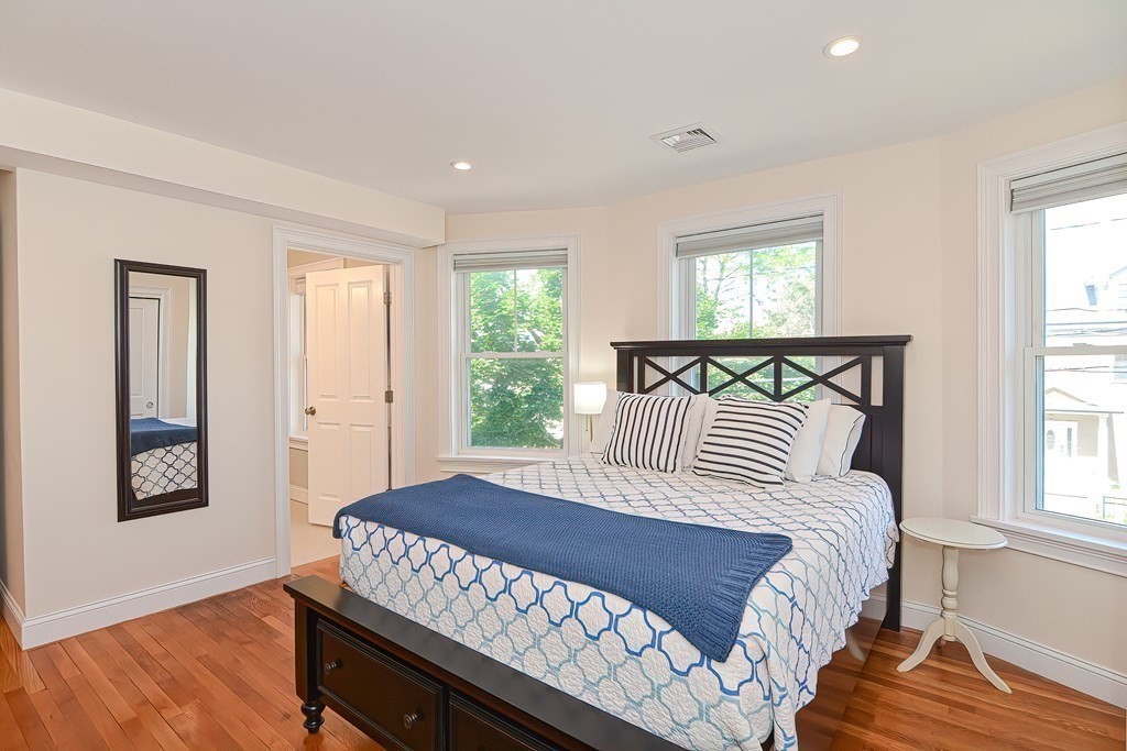 228 Cherry Street Newton, MA 02465 - Photo 30 of 42 a bedroom with a bed and wooden floor