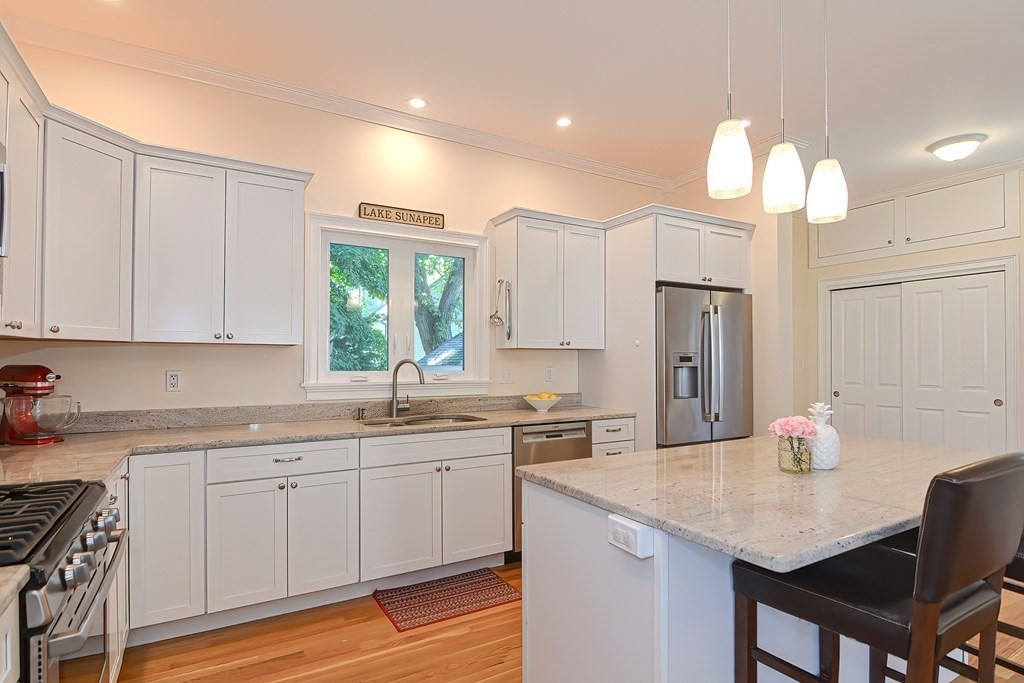 228 Cherry Street Newton, MA 02465 - Photo 3 of 42 a kitchen with a sink dishwasher a dining table and chairs with wooden floor