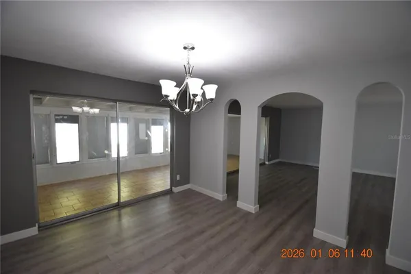 a view of a room with wooden floor and chandelier