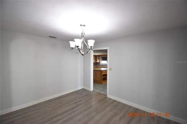 a view of a room with wooden floor and chandelier