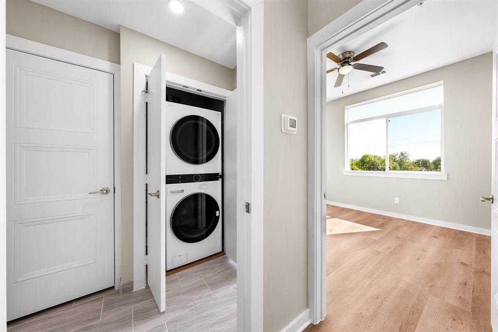 3522 Main Street, Unit 303 Rowlett, TX 75088 - Photo 10 of 23 Washroom featuring stacked washing machine and dryer, light wood finished floors, and a ceiling fan
