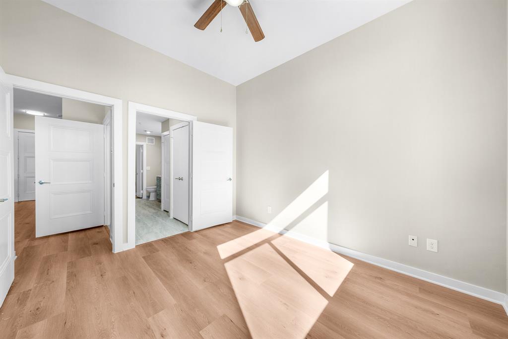 3522 Main Street, Unit 303 Rowlett, TX 75088 - Photo 12 of 23 Unfurnished bedroom featuring light wood-style floors, ensuite bath, and ceiling fan