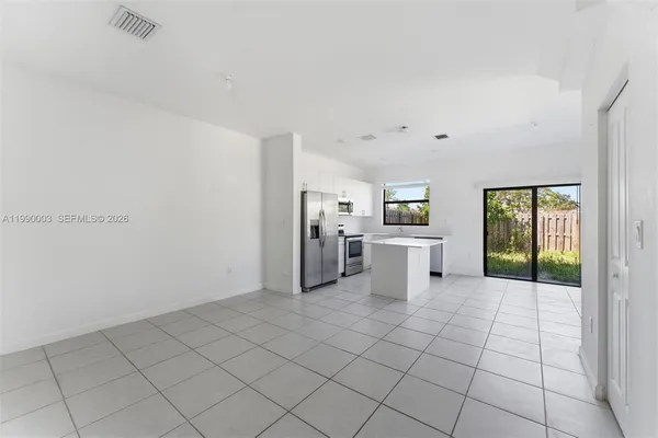 a kitchen with white cabinets and sink