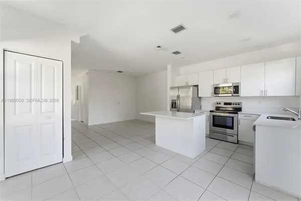 a kitchen with granite countertop white cabinets and stainless steel appliances