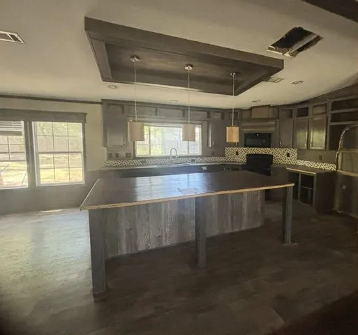 a kitchen with kitchen island a stove and a sink