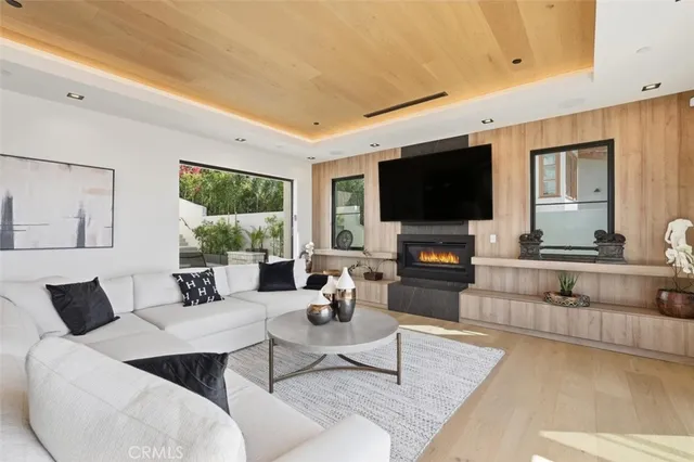 a living room with furniture a large window and wooden floor