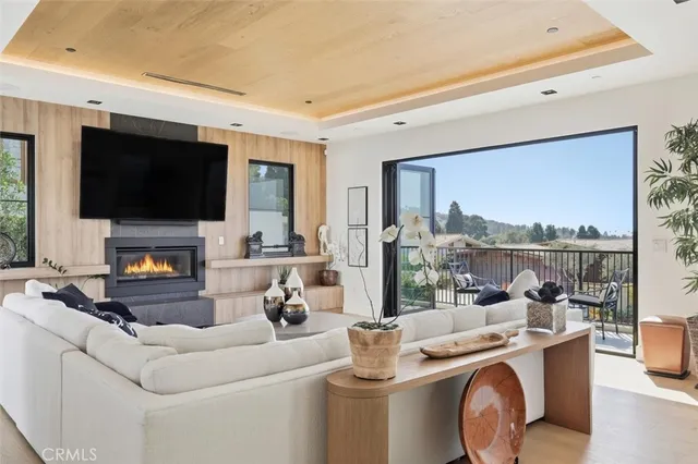 a living room with furniture a flat screen tv and a floor to ceiling window