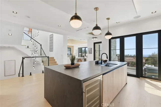 a kitchen with a sink a counter space appliances and cabinets