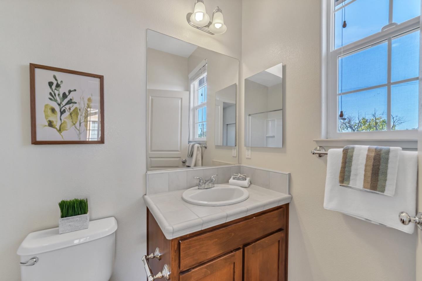 576 Almaden Walk Loop San Jose, CA 95125 - Photo 17 of 34 a bathroom with a toilet a sink a mirror and a window