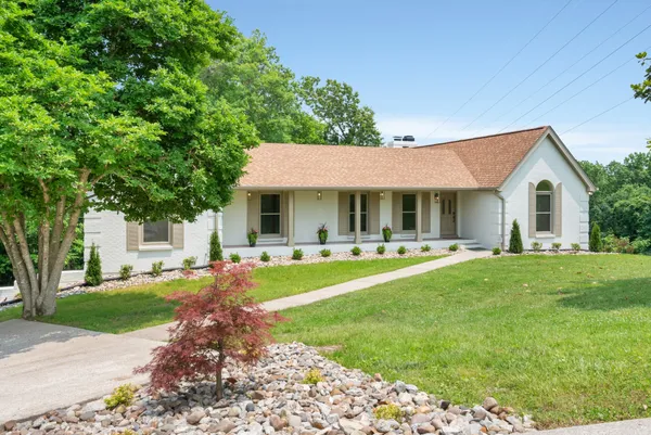 a front view of a house with swimming pool and porch with green space