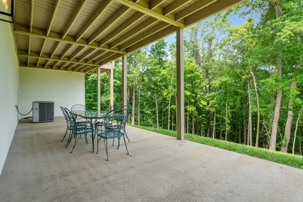 a view of a patio with table and chairs potted plants with wooden floor and floor to ceiling window