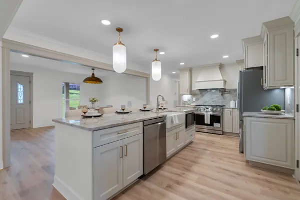 a kitchen with a sink and a stove with wooden floor