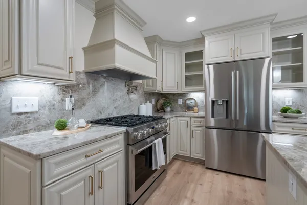 a view of a hallway with wooden floor and a bathroom
