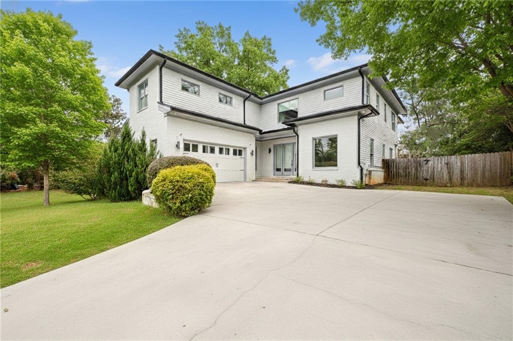 a view of a white house with a big yard and large tree