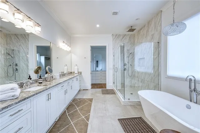 a large bathroom with a tub sink shower and a mirror