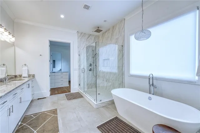 a spacious bathroom with a tub sink shower and mirror