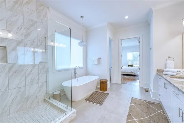 a spacious bathroom with a tub sink and mirror